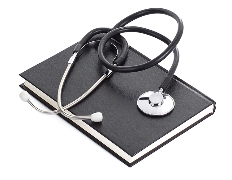 Stethoscope and book on white background.
